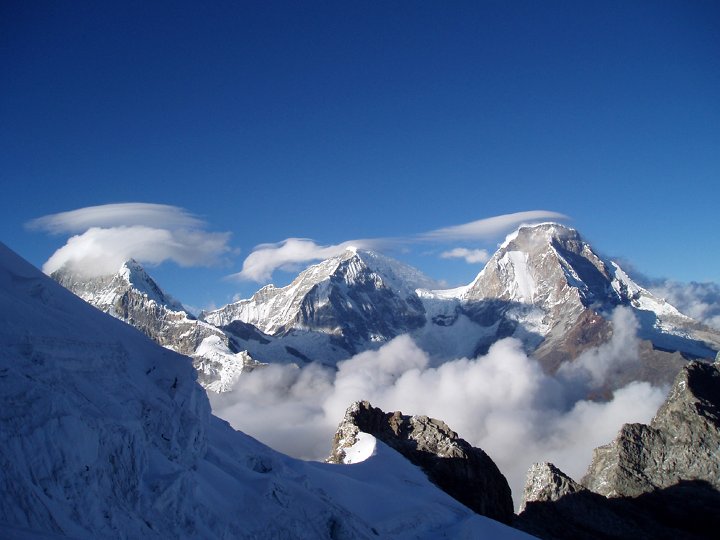 A hiker standing on a high mountain trail overlooking a valley in the Andes.